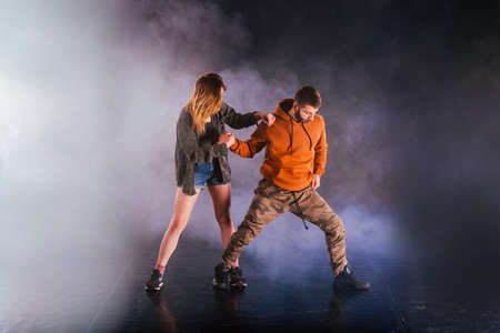 Dance couple shows off their moves the girl is throwing her leg high in the sky while the man is...