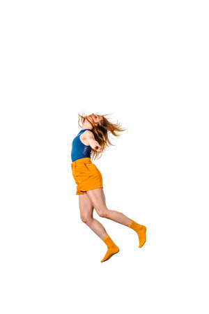 Happy young woman dancing against plain white backgroundの写真素材