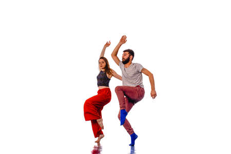 Dancers in action. Young couple of casual dancers performing modern dance on white background. School of dance artの写真素材
