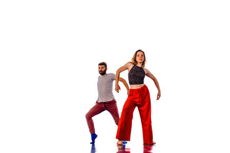 Romantic couple dancing together in studio, isolated on white background