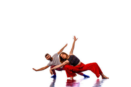 Couple of hip-hop dancers is dancing. Girl and boy performing street dance on white background. School of modern danceの写真素材