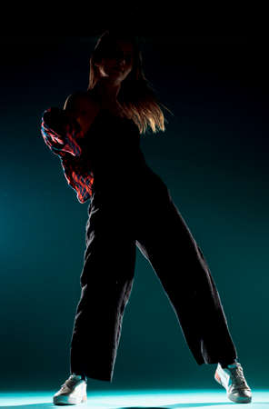 Caucasian female dancer exercising a contemporary dancing on dark wallの写真素材