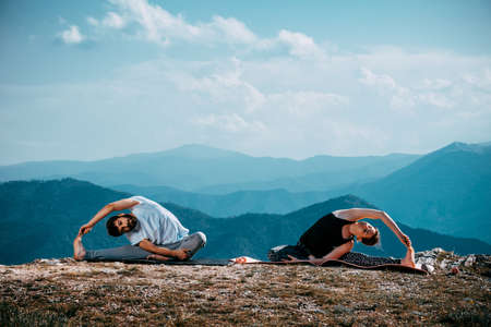 Couple meditating yoga at mountains.Travel lifestyle relaxation emotional concept adventure summer vacationsの写真素材