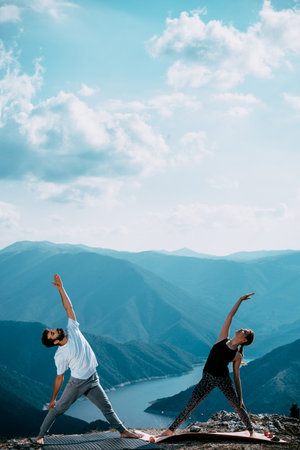 Active young people doing yoga in the background of the Caucasian mountainsの写真素材