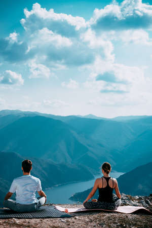 Yoga retreat, fitness, sport and lifestyle concept - smiling couple making yoga exercisesの写真素材