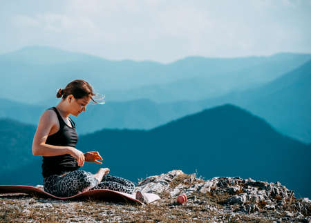 Yoga, fitness woman doing yoga exercises in the mountain peakの写真素材