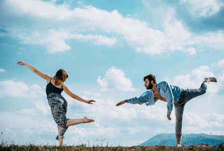 Couple is dancing contemporary dance. Young boy and girl performing modern dance at the mountain hillの写真素材