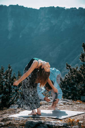 Summer holidays, love, relationship and dating concept - smiling couple dancing on the mountain peakの写真素材