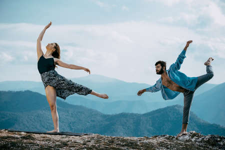 Summer holidays, love, relationship and dating concept - smiling couple dancing on the mountain peak