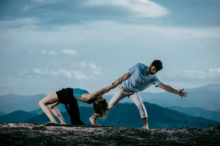 Skillful hip-hop dancers in movement. Young couple of modern dance dancing on the cliffの写真素材