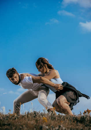 Romantic couple dancing and smiling outside at the mountain peakの写真素材