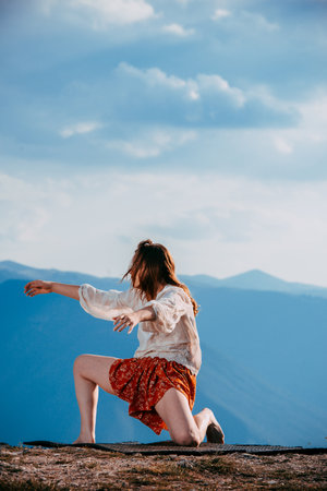 Happy beautiful free woman dancing on the mountain hill, playful having funの写真素材