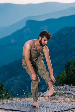 Stylish handsome hip-hop dancer in fashionable clothes dancing at mountain