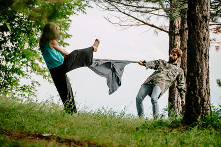 Couple is dancing contemporary dance. Young boy and girl performing modern dance on green lawn in...