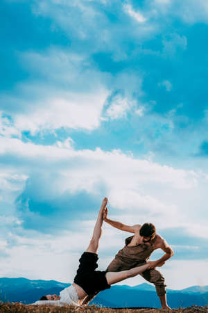 Romantic young loving couple dancing outdoors under blue sky at summertimeの写真素材