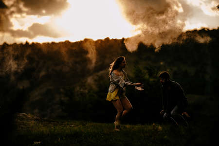 Hip-hop dancers in action. Young couple of casual dancers performing modern dance on green lawnの写真素材