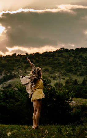 Silhouette of a beautiful female ballet dancer while dancing against sunset cloduy skyの写真素材