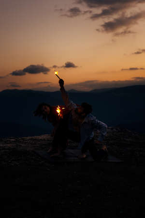 Summer holidays, love, relationship and dating concept - smiling couple dancing on the mountain peakの写真素材