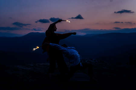 Hip-hop dancers in action. Young couple of casual dancers performing modern dance on peakの写真素材