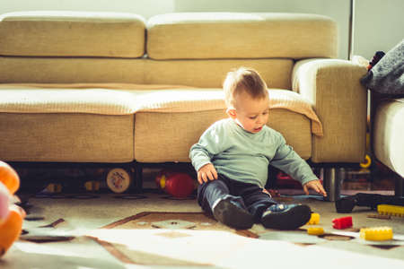 Sweet baby playing and looking happy in his homeの写真素材
