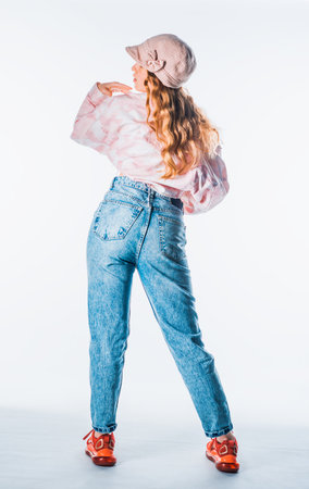 Studio body shot of an attractive woman posing in stylish clothes