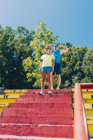 Sporty man and woman running up stairsの写真素材
