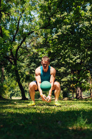Sporty guy exercising outdoor with the medecine ballの写真素材