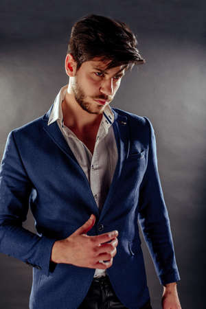 Man on black background in blue suit standing against black backgroundの写真素材