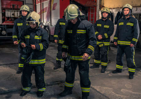 Group of firefighters standing confident with arms crossed. Firemen ready for emergency service.の写真素材