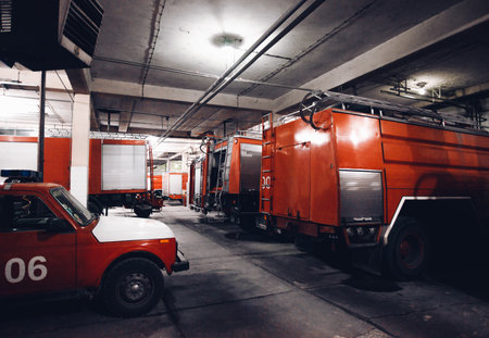Multiple fire trucks parked in a garage used for firefighting operationsの写真素材