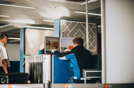 Airport security guard checking baggage for suspicious objects with an x-ray machineの写真素材