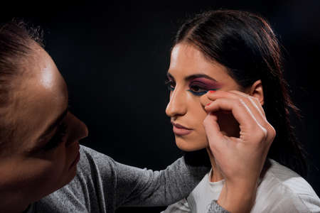 The beautician is applying a concealer on her skinの写真素材