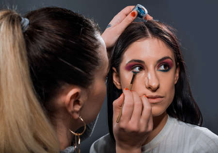 Portrait of a beautiful stylish girl having her makeup appliedの写真素材