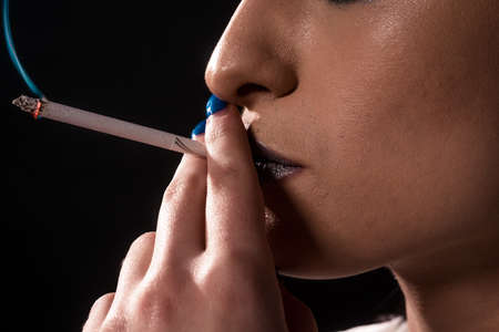 Close up portrait of beautiful woman with smoking, Cigarette smoking is dangerous to healthの写真素材