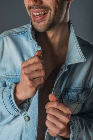 Picture of a young handsome macho man with abs and open denim jacket and jeans.の写真素材