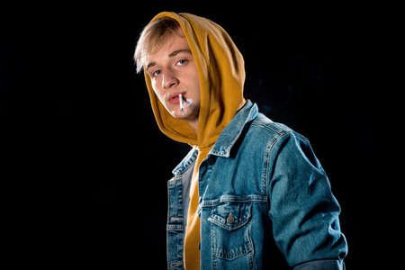 Portrait of a young attractive man dressed in yellow hoodie and sport jacketの写真素材