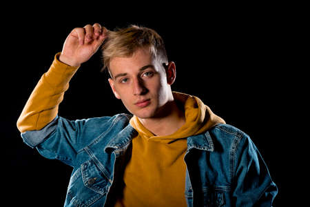 Attractive stylish man posing in casual cothing isolated on black background