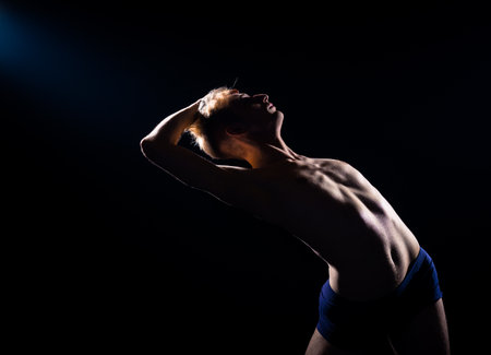 Dance performer during a dance practice against a dark backgroundの写真素材