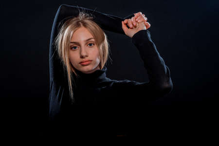 Portrait of a beautiful female model posing in trendy black pulloverの写真素材