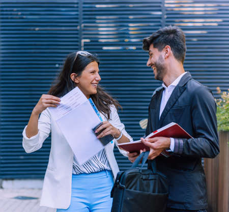 Business, communication and people concept - couple, colleagues or office workers talking on city streetの写真素材