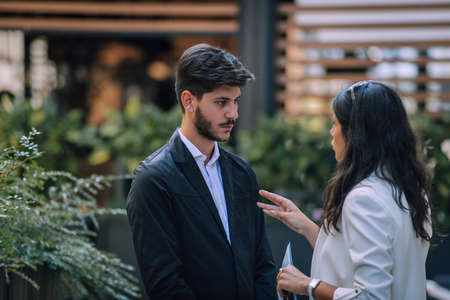 Two young business people standing outside on the city streetの写真素材