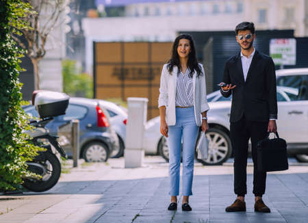 Picture of handsome man with suitcase and beautiful woman as business partners walking down the streetの写真素材