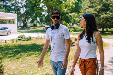 Couple spending time together while talking in the city parkの写真素材