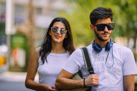 Portrait of happy couple with shopping bags after shopping in cityの写真素材