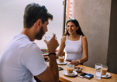 Charismatic man making laugh his beautiful female friend in coffee shopの写真素材