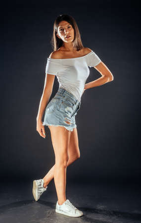 Attractive young female model posing against a black backgroundの写真素材