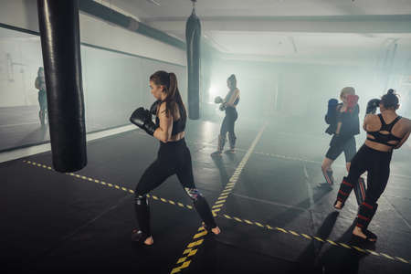 Female boxer training with punching bag in gym. Fitness and sport conceptの写真素材