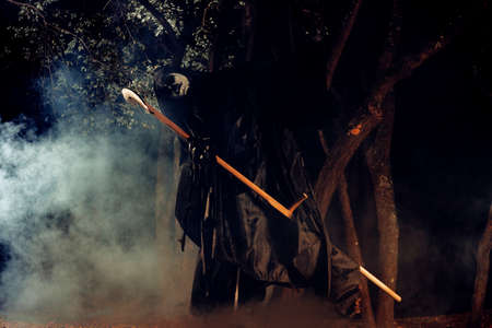 Portrait of grim reaper, the angel of death ( Azrael ) lurking through the woods at night surrounded...