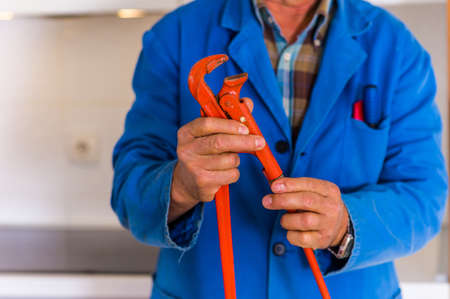Workman is working in the kitchen and holding his tools