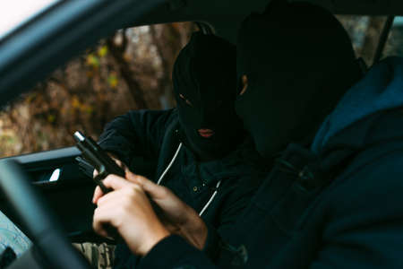 bank robbers putting their mask on prepared to do their next robbery,checking and loading their...